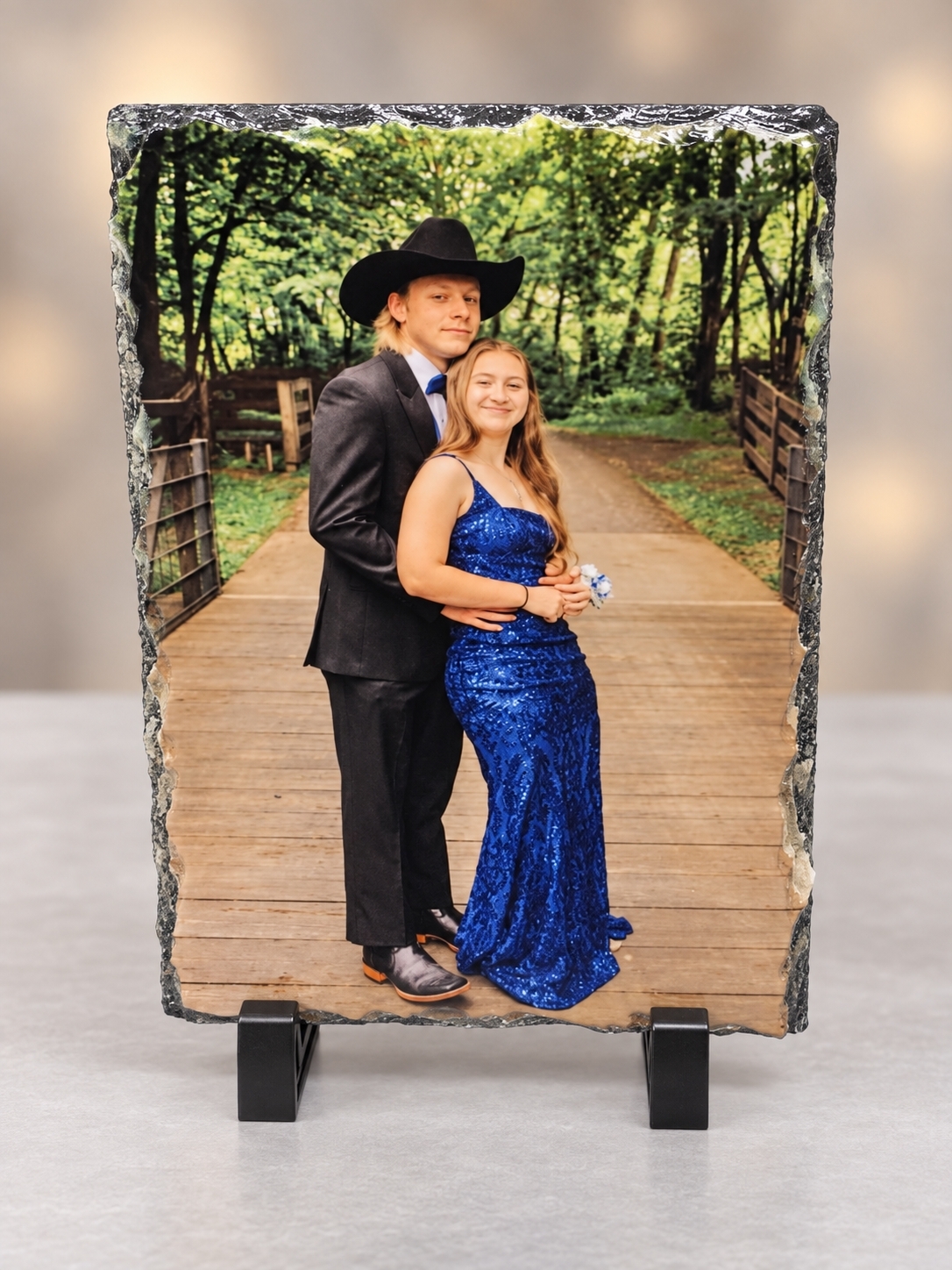 A young couple in formal dress on a wooden boardwalk, printed on a natural-edge slate keepsake