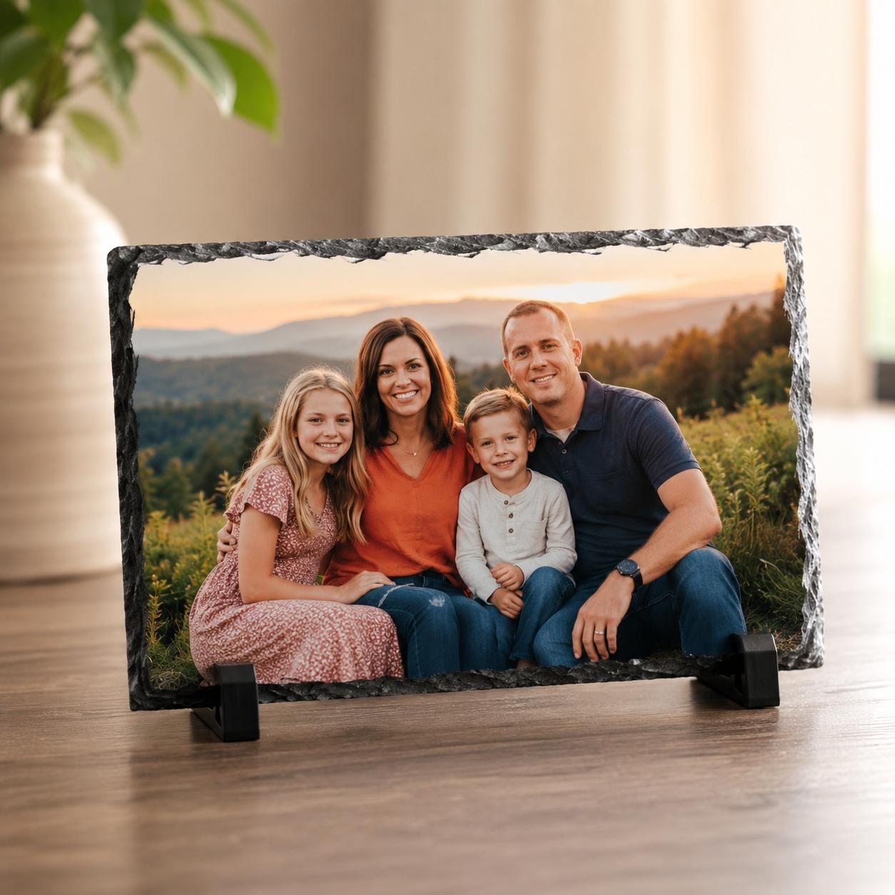 Family of four sitting together at a mountain sunset, printed on a natural-edge slate on its stand